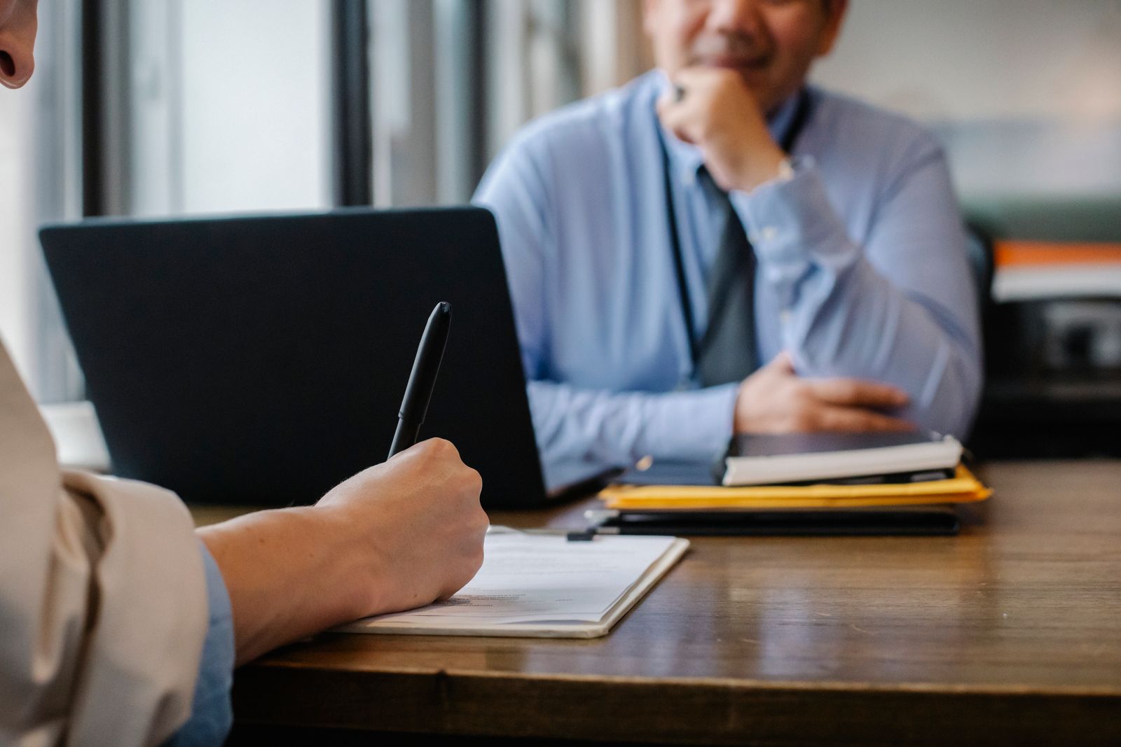 An advisor taking notes at a desk